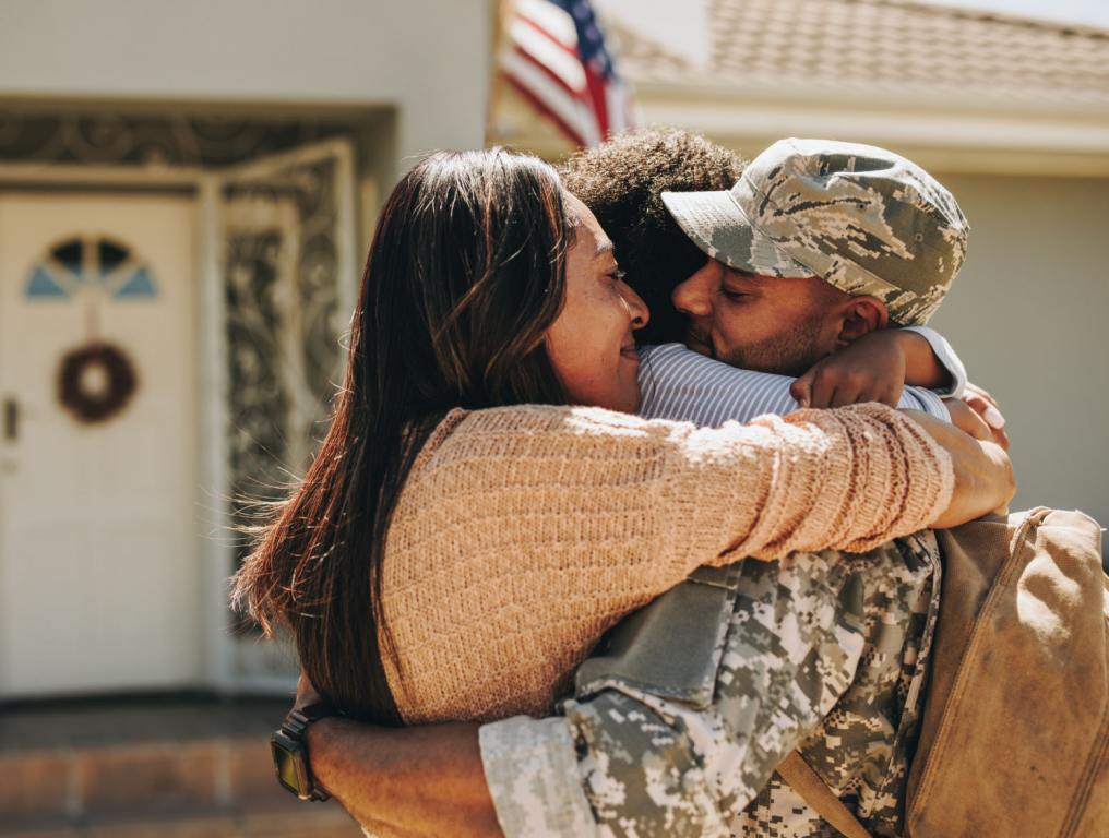 Military serviceman reuniting with his family after deployment.