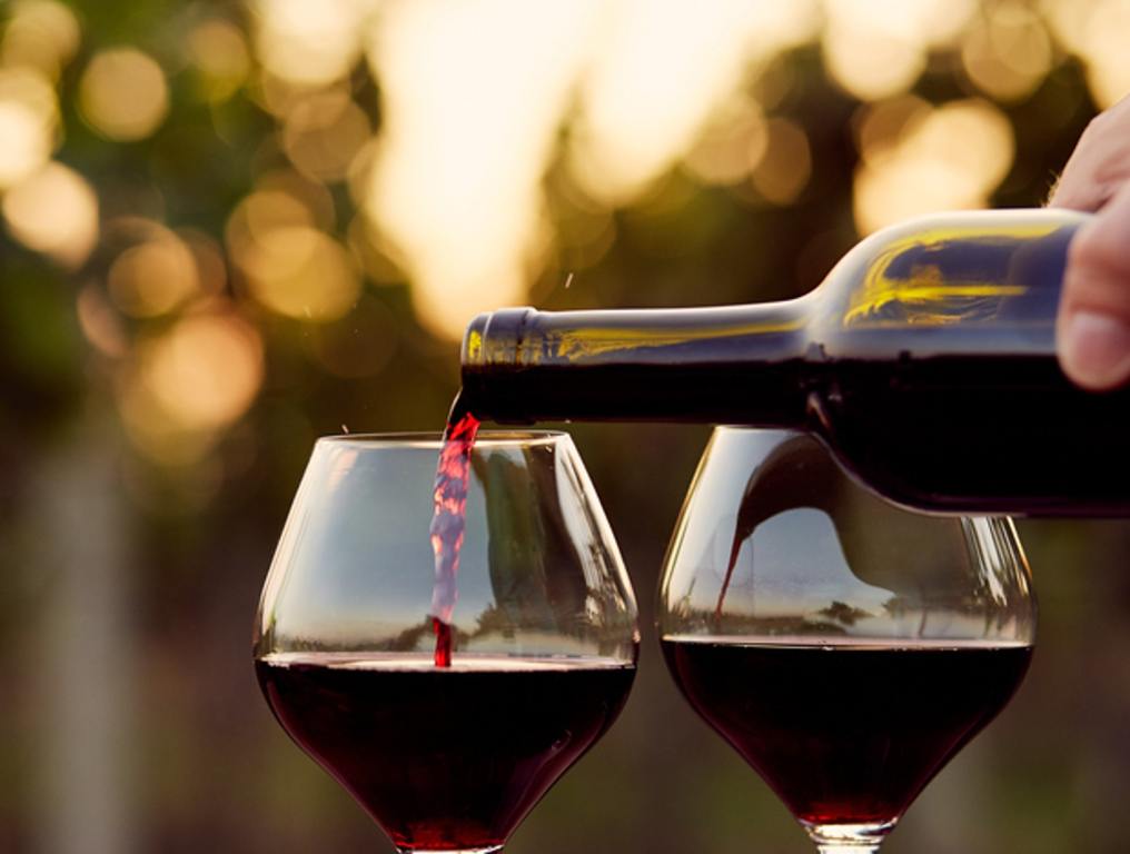 Pouring red wine into glasses in the vineyard, (2 Michigan Spots Named Among Best 'Wine Country' Hotels)