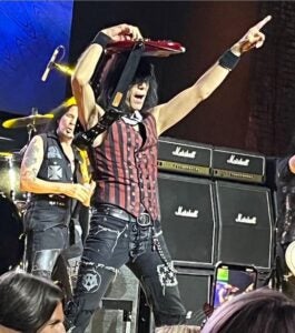 Quite Riot Bassist Rudy Sarzo on stage holding his bass over his head