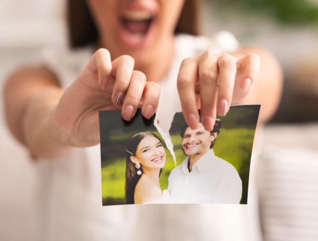 Unrecognizable Furious Girl Tearing Apart Photo Of Happy Couple Indoor (Love Gone Wrong: These Are Major Relationship Killers)