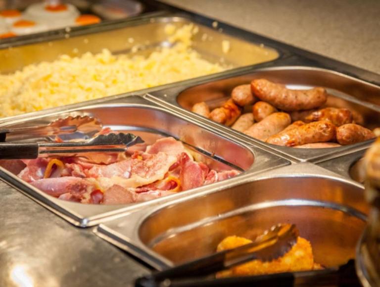 Hot counter containing warm breakfast items (You Should Probably Skip These Foods At A Breakfast Buffet)