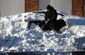 Dwayne Goings digs out a vehicle buried in snow with his shovel February 2, 2015 in Detroit, Michigan. Detroit received over a foot of snow during a storm that has crippled much of the Midwest canceling thousands of flights around the country.