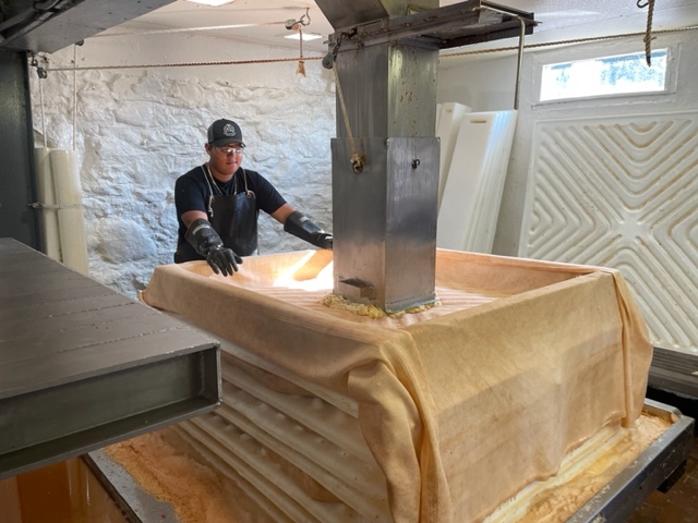 man stands near a machine used to help make cider at Franklin Cider Mill: Bloomfield Hills