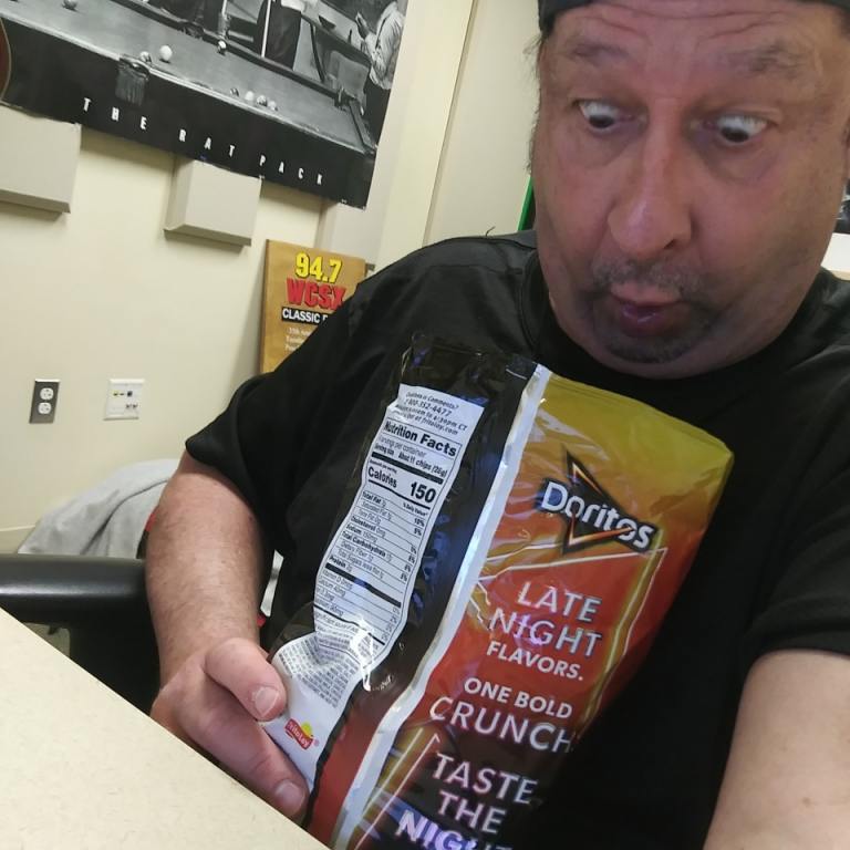 WCSX's screamin scott holding a bag of Doritos chips new flavor that is a mystery flavor