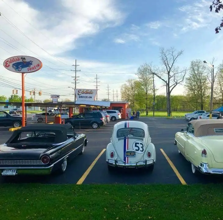 eddies driv-in parking lot with a herbie the love bug car parked in the back